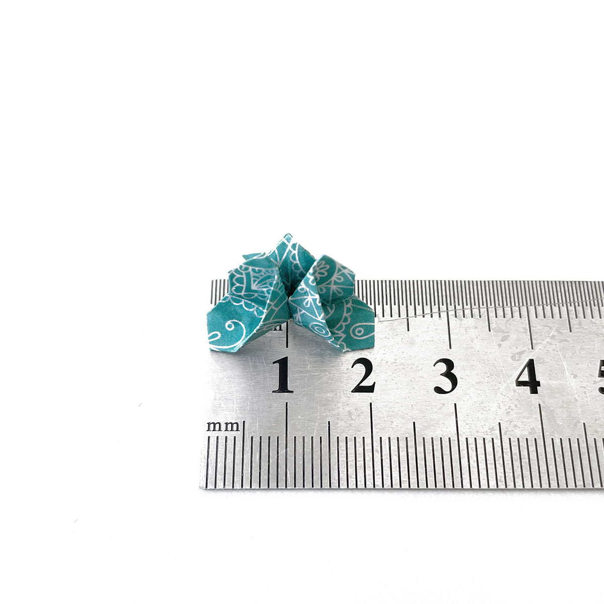 blue origami butterfly stud earrings places on the ruler and it shows 2 cm width