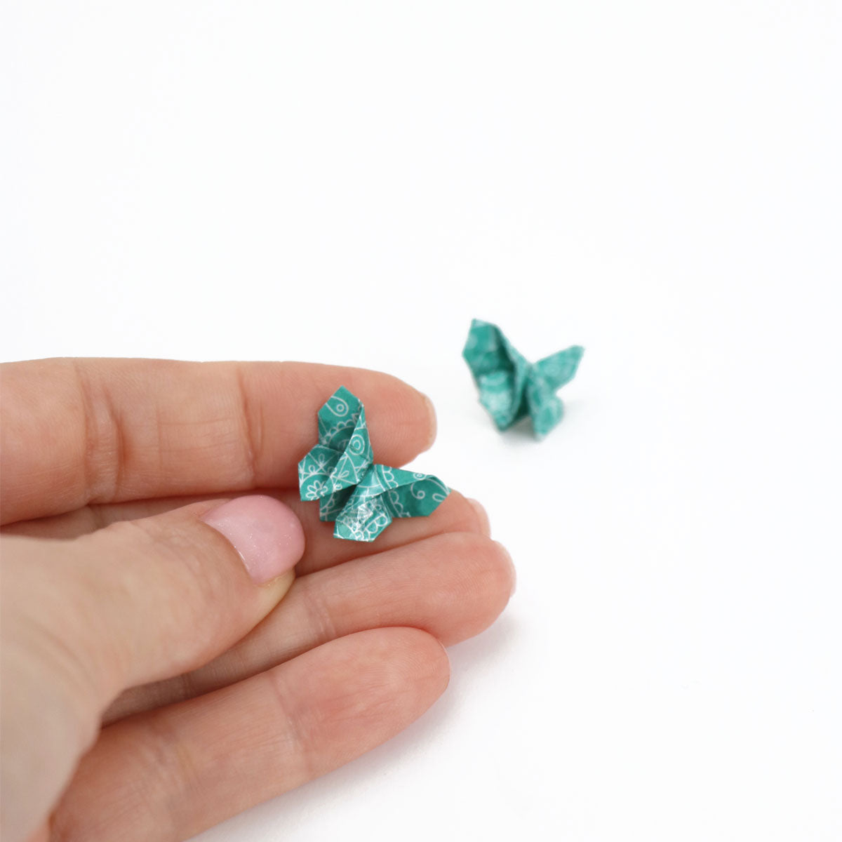 blue origami butterfly stud earrings one peace between women fingers